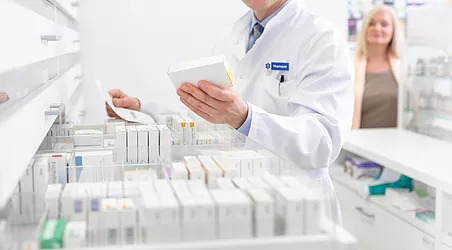 Pharmacist looking at a medicine box